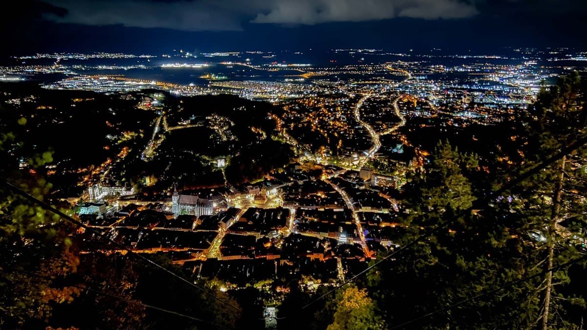Brașov's old town lit up at night, seen from Tâmpa Mountain